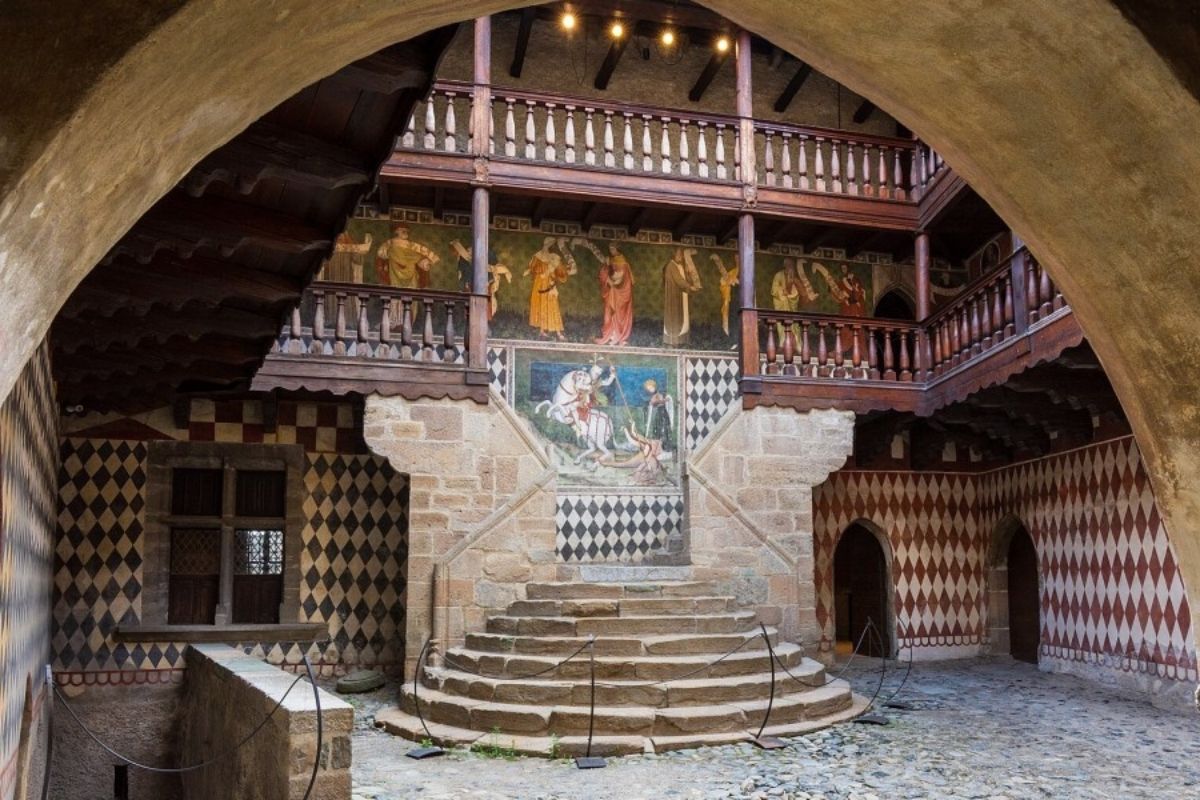 Interno del castello di Fénis, mostra affreschi e dettagli architettonici.